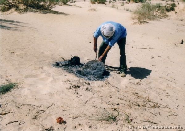 image-121 <p><b>Sahara</b></p>
<br>
<div align=left>
<p>Nach zehn Minuten wird der inzwischen fast schwarze Fladen herausgenommen, umgedreht und noch mal bedeckt. Nach weiteren zehn Minuten ist das Brot fertig, der Sand und die Asche werden einfach abgeklopft.</p>
</div>