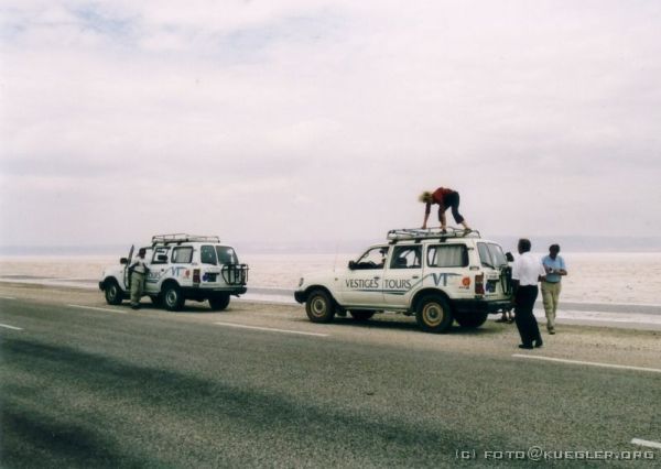 image-151 <p><b>Chott El Djerid</b></p>
<br>
<div align=left>
<p><b>26. September 2003: Chott El Djerid, Tozeur</b></p>
<p>Wir brechen nach dem Ausschlafen in Douz auf und machen uns auf den Weg zu unserem nächsten Ziel: Tozeur. Um dahin zu gelangen, müssen wir den großen Salzsee, das Chott El Djerid überqueren.</p>
<p>Die Kruste des Salzsees sieht aus wie Erde, ist aber brüchig und das Betreten hat in der Vergangenheit schon ganzen Karawanen das Leben gekostet. Auf einem festen Damm ist eine Asphaltstraße gebaut, die man tunlichst nicht verlassen sollte.</p>
</div>